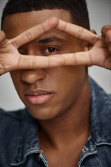 portrait of stylish african american man in denim attire gesturing at camera, fashion concept