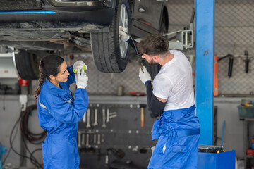 Car technicians analyze, fix wheel issues in garage, using precise tools for optimal alignment.