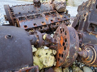 Rusty motor of a shipwreck on a beach