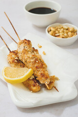 Chicken kebabs with peanuts on skewers with a slice of lemon, Asian cuisine.