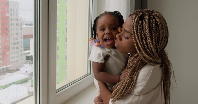 Mother holding little unhappy sad crying kid in room, slow motion, woman waiting for her husband, daddy to hel look after naughty child parenthood, motherhood childhood