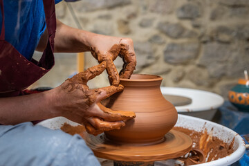 A piece of ceramic taking shape on the wheel by expert hands.