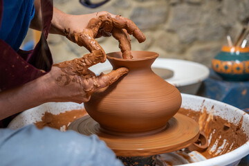 A piece of ceramic taking shape on the wheel by expert hands.