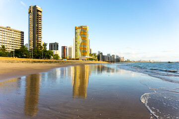 Apartment Buildings are mirroring at the Beach of Piedade  early in the morning, just after sunrise. Jaboatao dos Guararapes, Pernambuco - obrazy, fototapety, plakaty