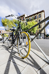 Fototapeta na wymiar A stroller bicycle leaning on a metal railing on an urban street