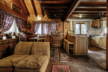 a rustic cabin with an open kitchen with a peninsula and a living room with wooden rocking chairs...