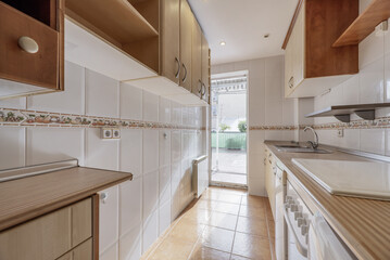 Kitchen furnished with white tones and light wood and access to an outdoor terrace