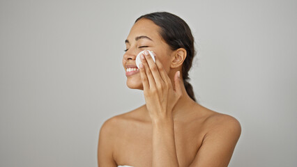 African american woman smiling confident cleaning face with cotton pad over isolated white...