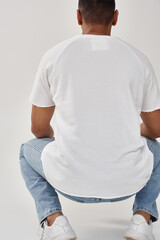 stylish african american man in trendy casual jeans and white t-shirt, copy space for advertising