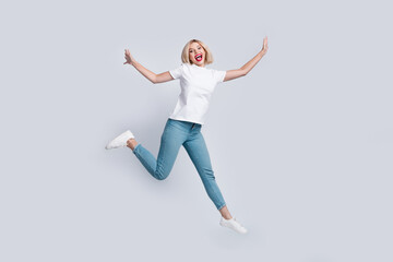 Fototapeta na wymiar Full size photo of funny crazy funky woman dressed white t-shirt denim trousers jumping having fun isolated on white color background