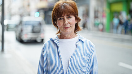 Middle age woman standing with serious expression at street