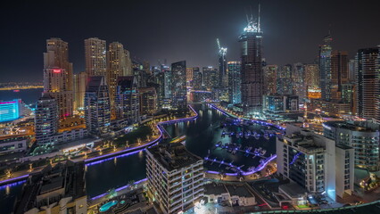 Obraz premium Panorama showing Dubai Marina skyscrapers and JBR district with luxury buildings and resorts aerial night timelapse
