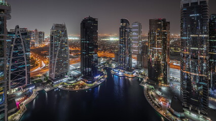 Fototapeta na wymiar Tall residential buildings at JLT aerial night timelapse, part of the Dubai multi commodities centre mixed-use district.
