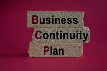 Business Continuity Plan symbol. On a bright red background brick blocks with the text BCP Business Continuity Plan. Manufacturing of wooden toys.