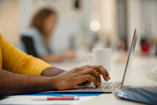 Close-up Of African American Man's Hands Using Laptop At Office