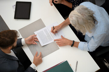Adult man signing contract during interview with lawyer