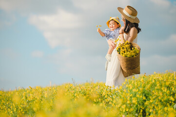 Mother with little child in flower blooming garden. woman with son in green leaves,happy family...