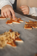 Child making pizza in the shape of a Christmas tree, activity idea