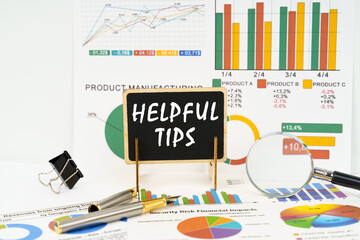 Against the background of business graphs, a board with the inscription - Helpful Tips