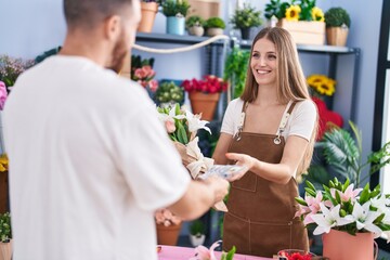 Man and woman customer paying for boquet of flowers at flower shop