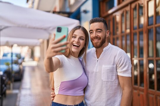 Man and woman couple smiling confident make selfie by smartphone at street