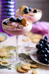 Wine mousse with grapes and cookies in a glass bowl