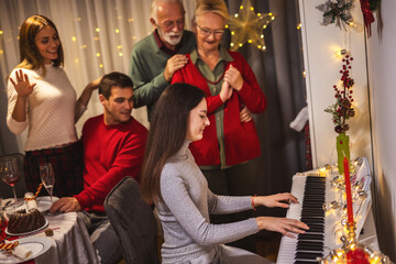 Granddaughter playing a piano for her family on Christmas Eve.
