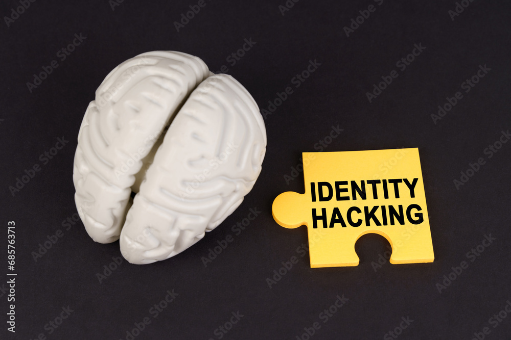 Poster on a black surface lies a brain and a yellow puzzle with the inscription - identity hacking
