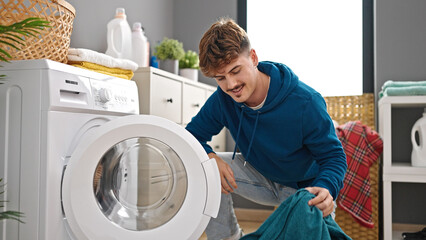 Young hispanic man smiling confident washing clothes at laundry room