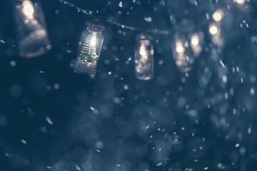 Christmas garlands with Christmas trees in bottles on a dark blue background.