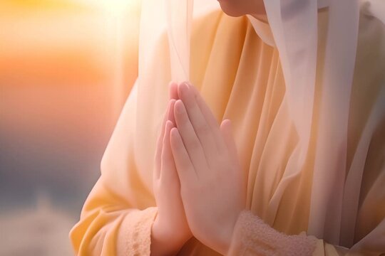 serene moment of a woman in a hijab praying, with hands pressed together, against a warm, glowing sunset background.
