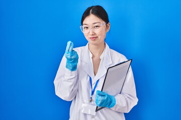 Chinese young woman working at scientist laboratory doing money gesture with hands, asking for salary payment, millionaire business
