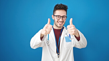 Naklejka premium Young hispanic man doctor doing thumbs up over isolated blue background