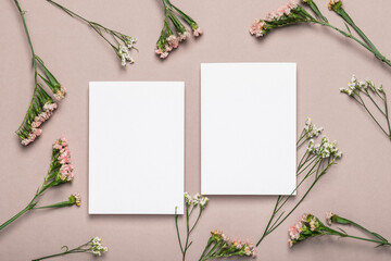 Two empty blank forms and pink flowers on a brownish background. Greeting card.