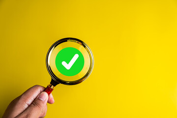 Magnifier enlarging the correct or check mark on yellow background. Business industrial quality control and voting concept. Approval and Contract assignment theme...