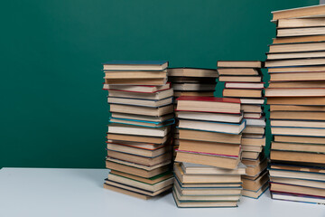 A simple composition of many books, stack or pile of books on wooden table, one of them open with copy space.