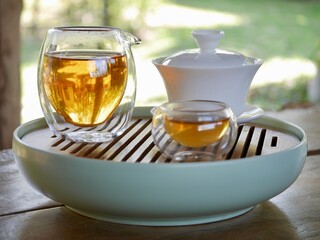 tea from glass teapot on wooden serving tray, Tea making process, Glass teapot at the tea ceremony...