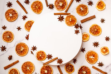 Flat lay composition of spices and dried fruits on a stand. Sprigs of orange, cinnamon and star...