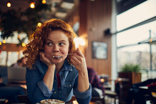 Young woman enjoying sweet treat in cozy cafe