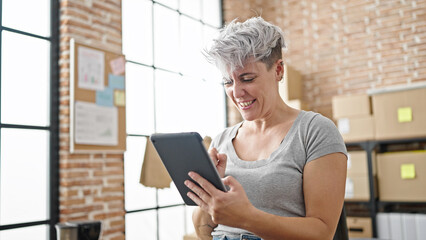 Young woman ecommerce business worker using touchpad smiling at office