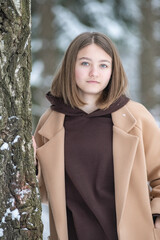 Portrait of a young beautiful girl in a winter forest.