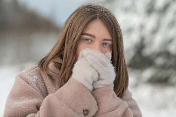 Portrait of a young beautiful girl in a winter forest.