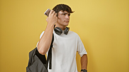 Smart young hispanic teenager student immersed in listening to serious voice message on smartphone,...