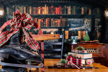 ice skates hanging form old sled with Christmas presents and vintage radio with old library background