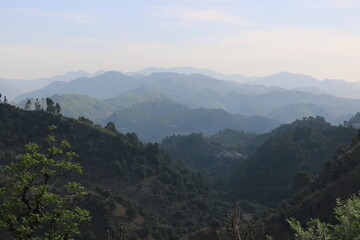 beautiful vertical shot of a long mountain peak with clouds