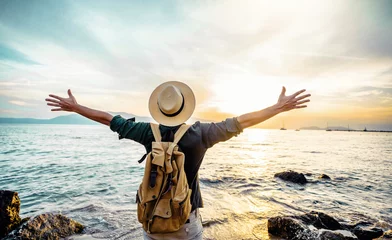 Foto op Canvas Happy man raising arms up enjoying sunset on the beach - Delightful traveler standing with hands up looking morning sunrise - Self care, traveling, wellness and healthy life style concept © Davide Angelini
