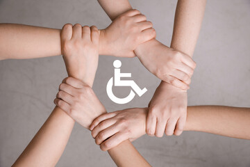 Inclusion concept. People holding hands together around international symbol of access together on...