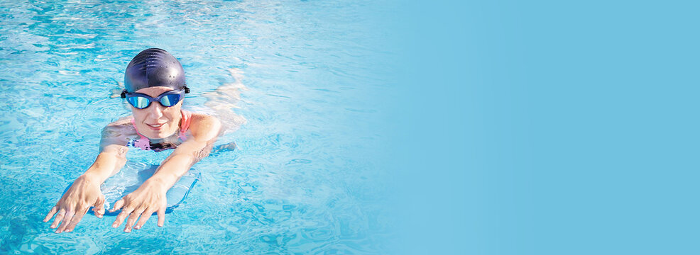 Banner of active fitness, exercise senior woman (over age of 50) in goggles, cap doing water  sport, aerobics with swim board in the swimming pool. Healthy lifestyle. - Powered by Adobe