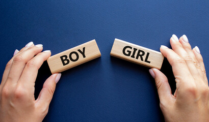 Boy or Girl symbol. Concept word Boy or Girl on wooden blocks. Man hand. Beautiful deep blue...