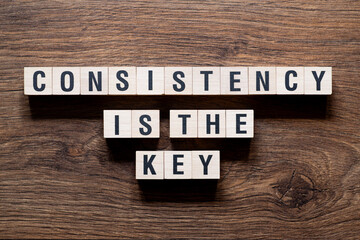 Consistency is the key - - word concept on building blocks, text